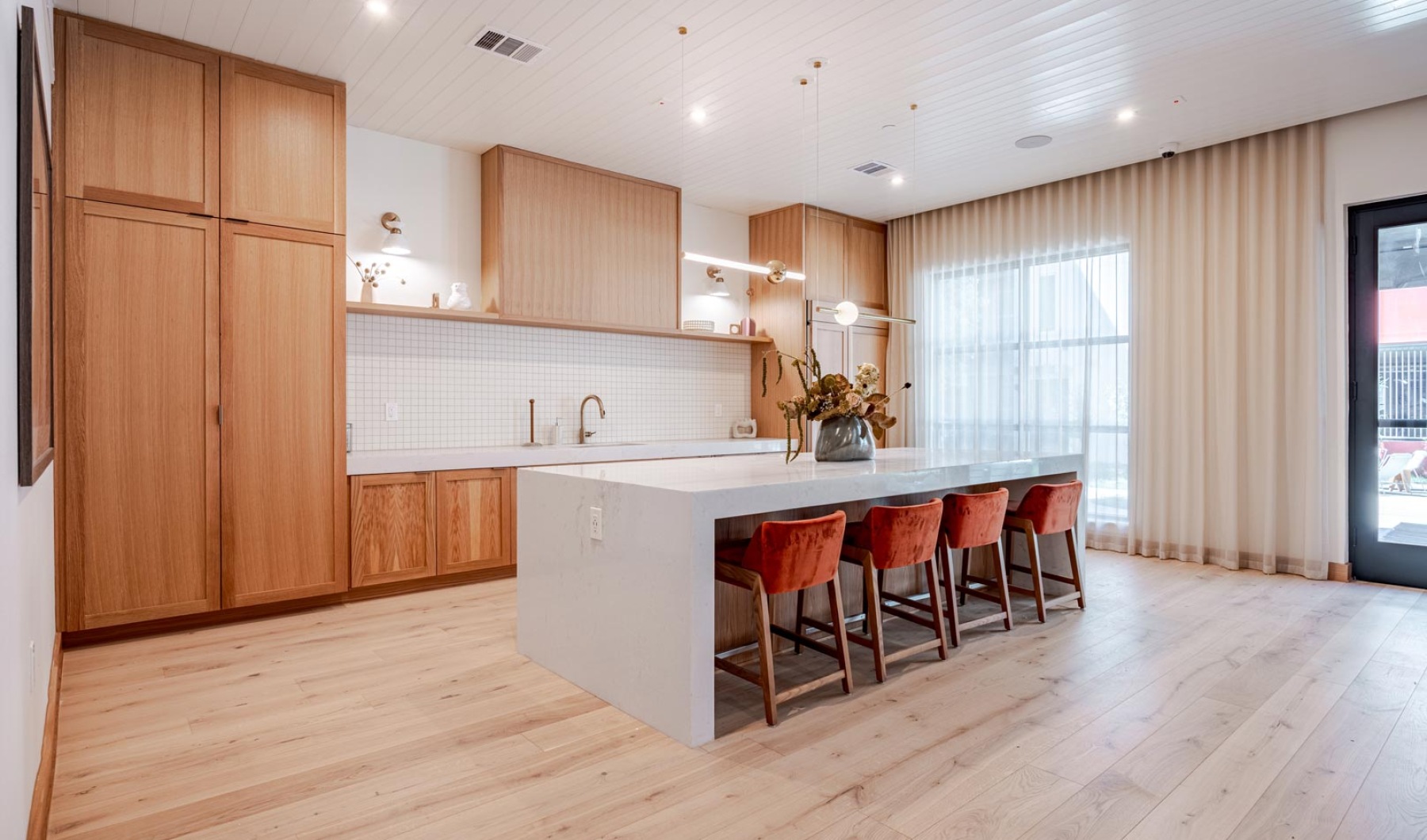 clubhouse amenity space with island seating, sink, and refrigerator 