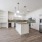 kitchen showcasing green backsplash, island, and built-in desk and shelves