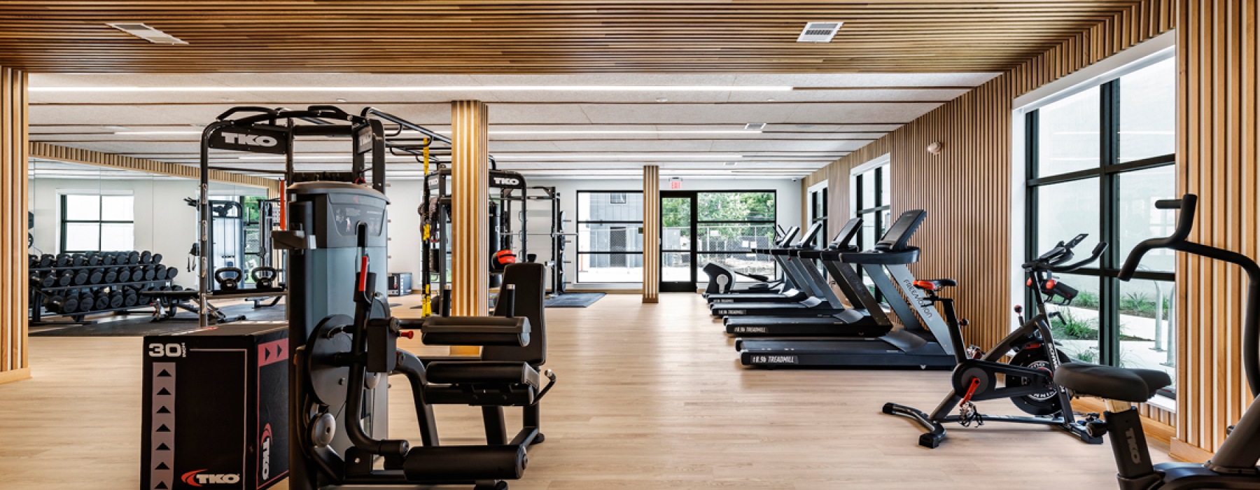 gym featuring modern wood details on the wall and high tech gym equipment 